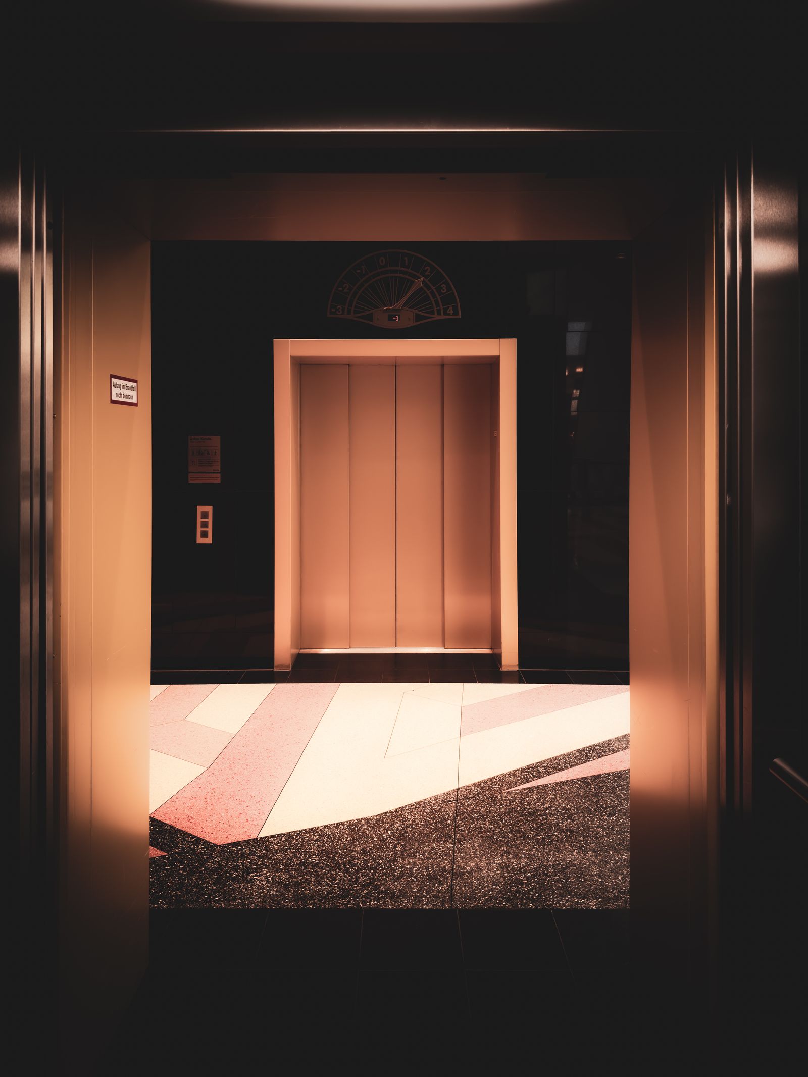 Closed stainless elevator entrance doors in a modern office building lobby
